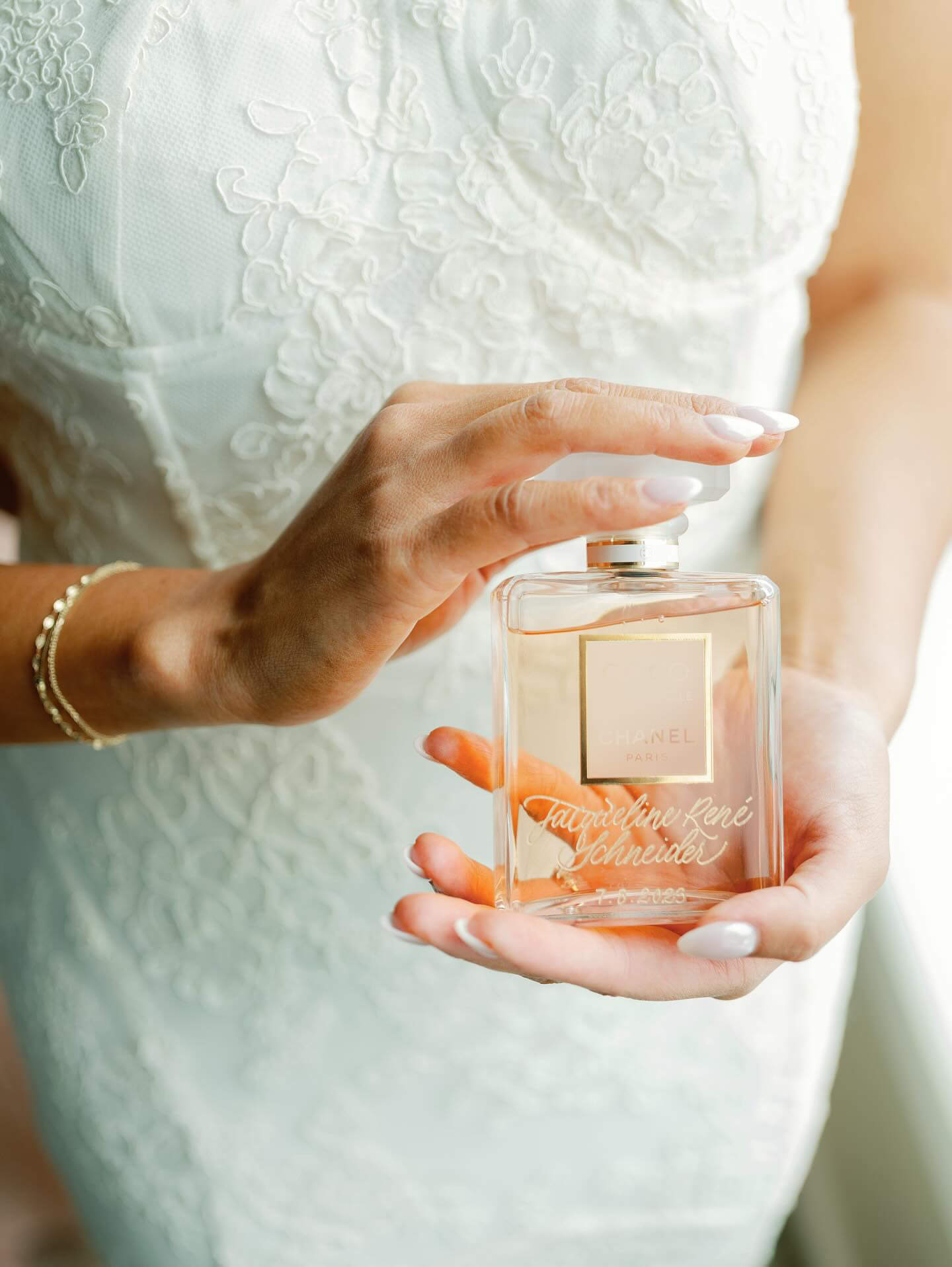 Bride holding her Chanel perfume engraved with her name.