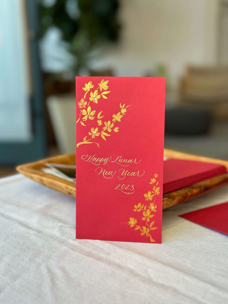 Live calligraphy on red envelope at Saje Wellness San Francisco