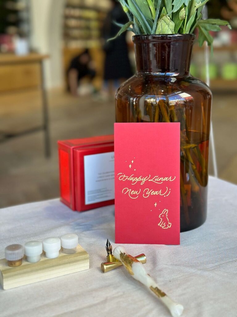 Live calligraphy on red envelope at Saje Wellness San Francisco