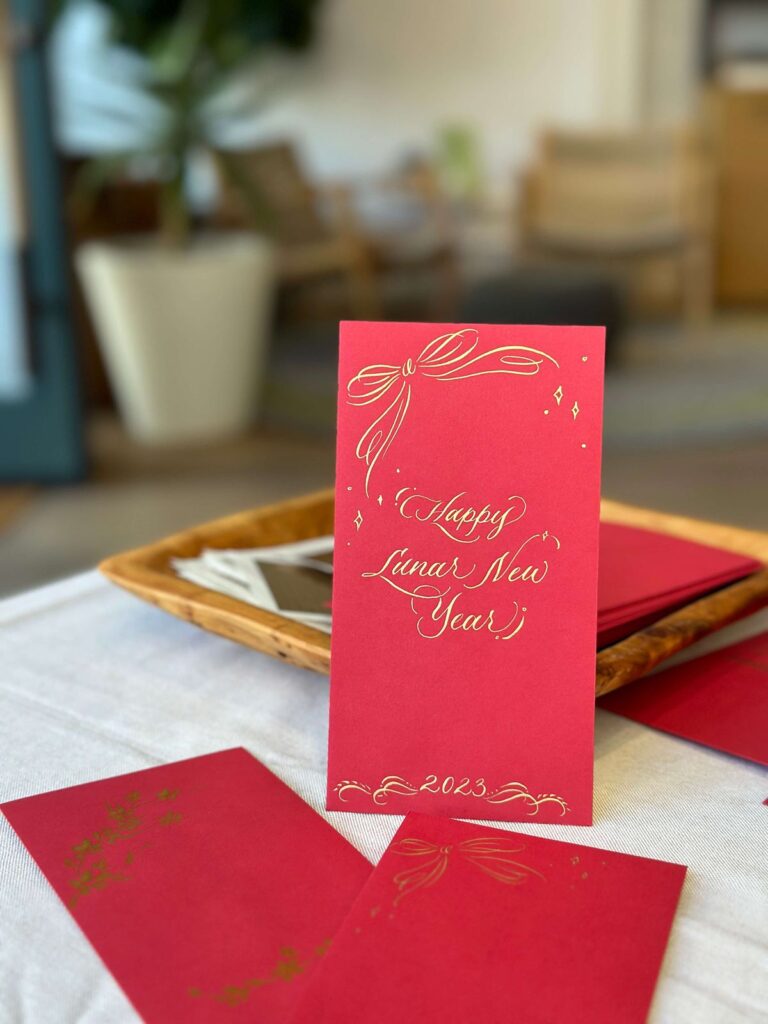 Live calligraphy on red envelope at Saje Wellness in San Francisco