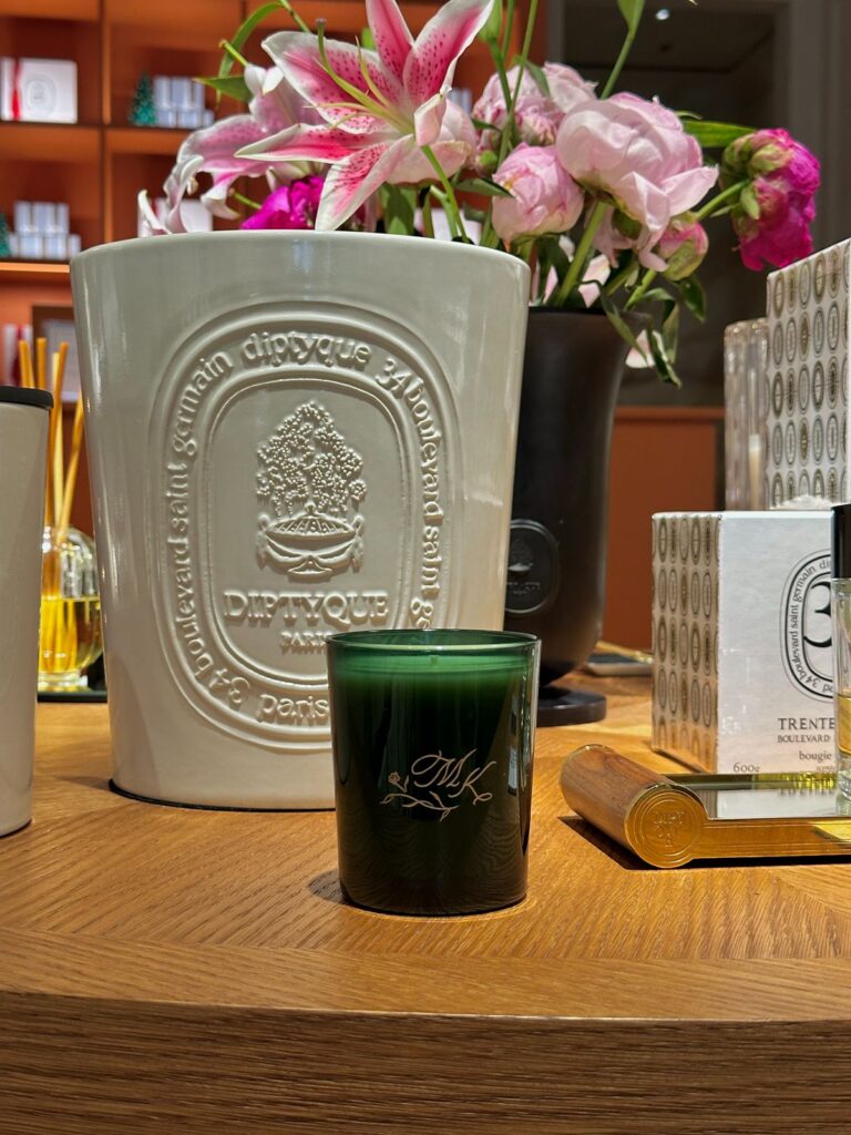 Live engraving of initials onto a glass candle vessel at event.
