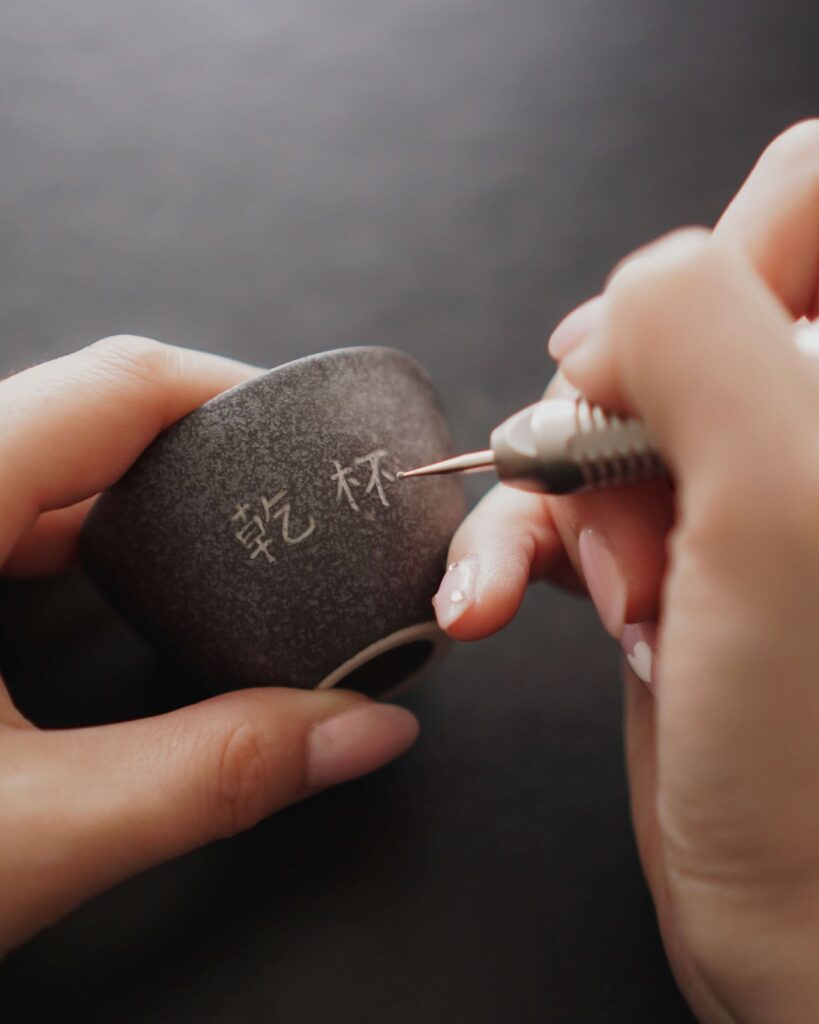 Close-up of engraving on ceramic sake cups.