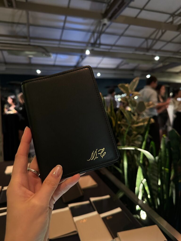 Black leather passport cover embossed with gold initials.