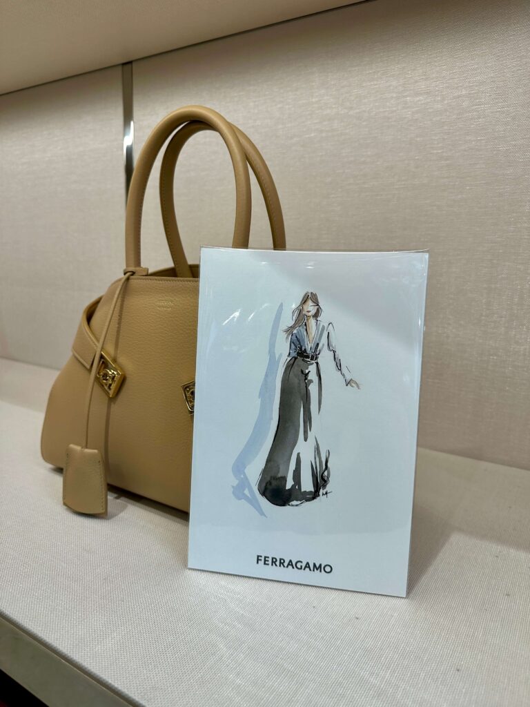 A fashion illustration of a woman in a blue blouse and black skirt.